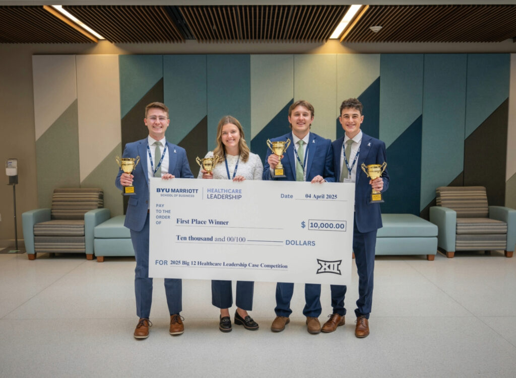 Four students hold trophies and an oversized check.
