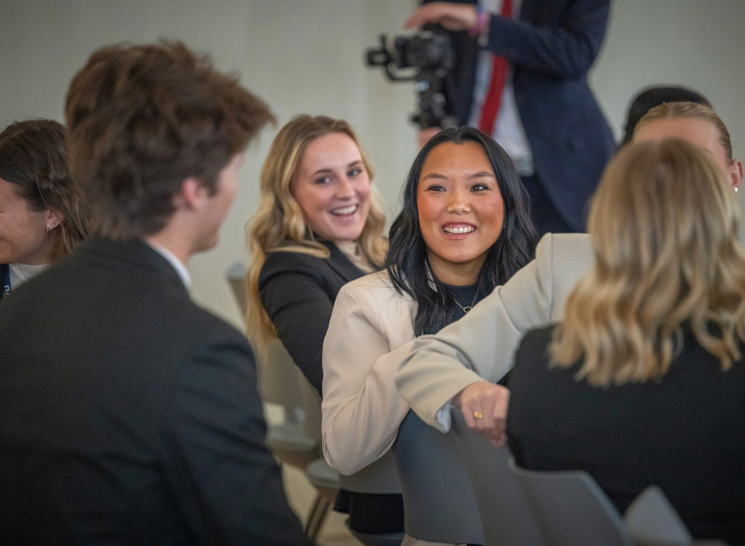 A student turns to talk to someone behind her at a conference.
