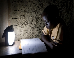 A boy in Essam village, Ghana, reads by the light of a rechargeable LED light provided by Empower Playgrounds, Inc. The battery-powered lights are recharged by an electricity-generating merry-go-round at the school.