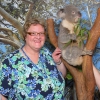 White stands next to a Koala bear while on a trip to Australia