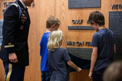 Three of the Taylor children unveil their father's name on BYU's Memorial Wall.