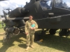 Trevor Findlay and his son in front of an AH-64 Apache helicopter.