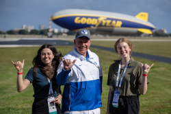 ExDM students Kylie Jensen (left) and Camille Cooper (right) with ExDM adjunct professor Justin Durfey. The trio visited the Goodyear Blimp as part of the Stadium Managers Association seminar.