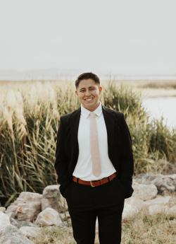 Aaron Cruz Morales standing outside in a suit