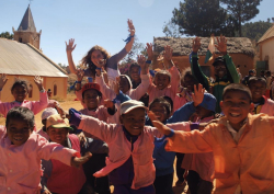 In high school, Ashley Wallace volunteered with Youthlinc and served in Madagascar for two weeks. Photo shows Ashley Wallace (a brown-haired girl) behind several Malagasy children.