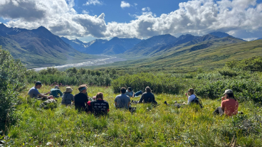 A photo of students having a class discussion in the mountains.