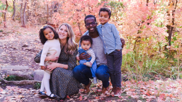 Nzojibwami and his wife and three children surrounded by fall leaves.