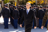 President Lund smiles at the camera with ROTC cadets lined up and facing the background behind him.