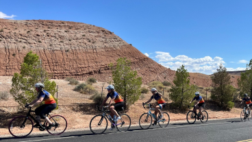 Ten cyclist in matching jerseys ride along a road through Utah.