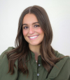 Ellie Draper smiles in a headshot wearing a dark green blouse.