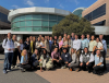 Students crowd together in front of a building for a group photo.