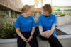 A female student and Sharon Eubank chat in matching t-shirts while sitting outside of the BYU library.